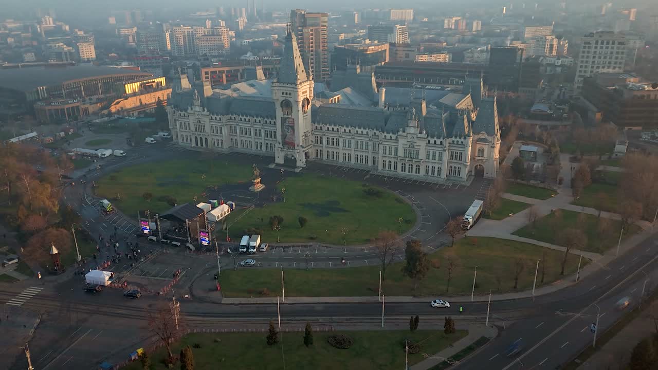 Drone hyperlapse of the Palace of Culture in Iasi with traffic passing nearby during foggy day