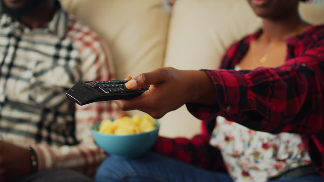 Ragazza che cambia canale alla televisione per trovare un film
