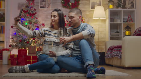 una pareja encantadora en el día de navidad bebiendo champán.