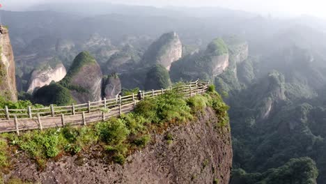 aerial: female hiking amazing bajiao shan mountain trail, china mountain lookout