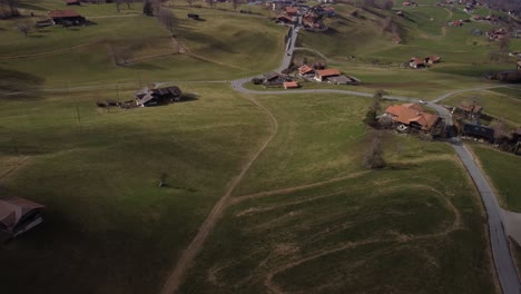 Roads-leading-to-farmland-buildings,-Swiss-countryside,-mountain-of-snow