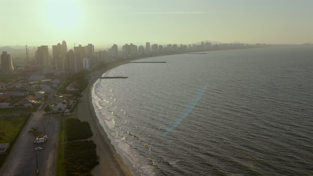 Amazing aerial municipality skyline at sunset with coastline curving beside the ocean, Balneário Picarras, Santa Catarina, Brazil