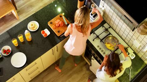 lesbian couple serving food in kitchen at home 4k