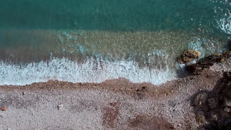 Vista-Aérea-De-Arriba-Hacia-Abajo-De-La-Playa-Tropical-Paradisíaca,-Salpicaduras-De-Olas-De-Agua-Turquesa