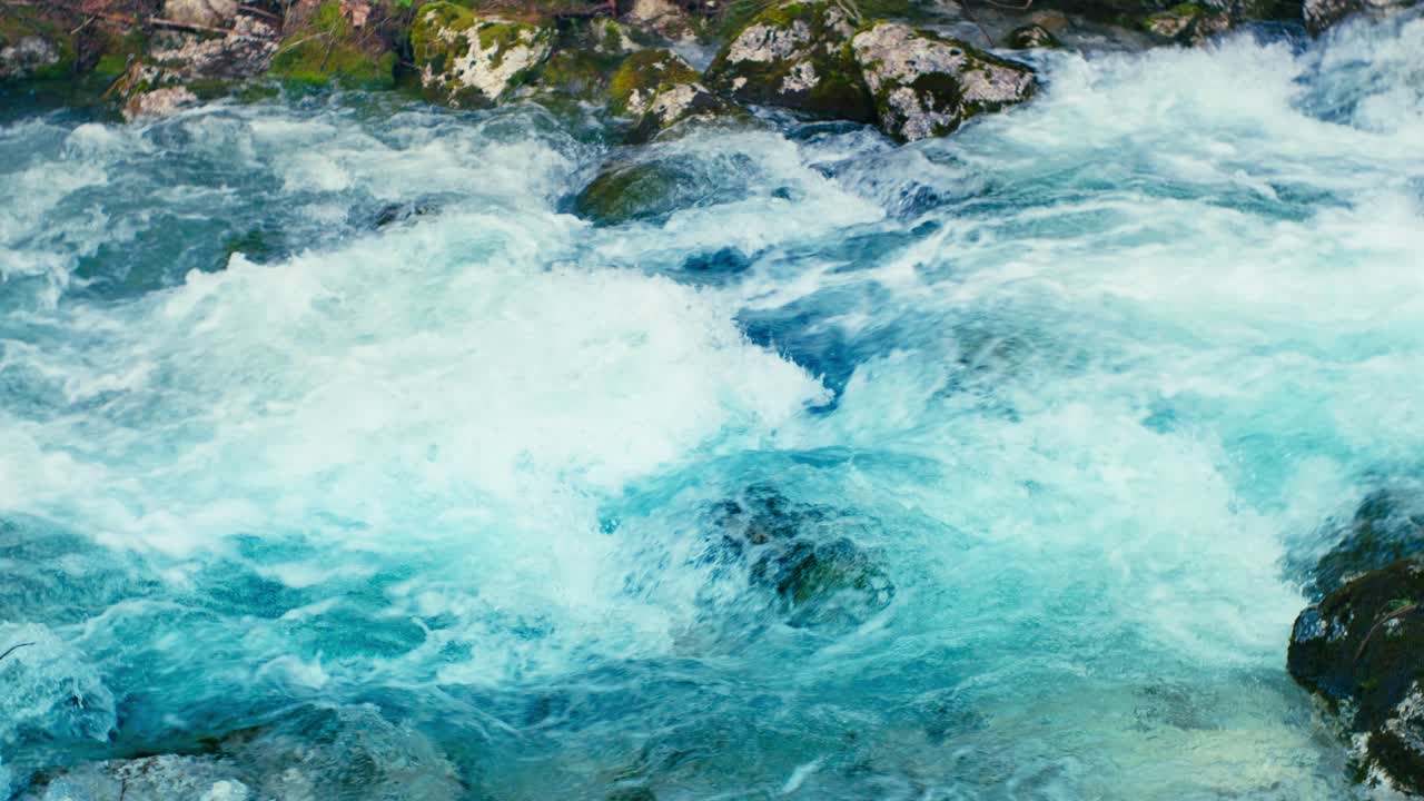 Immerse yourself in the pristine beauty of the Julian Alps with this stunning capture of a mountain river near Kranjska Gora, Slovenia. Crystal-clear turquoise water flows over smooth river rocks.