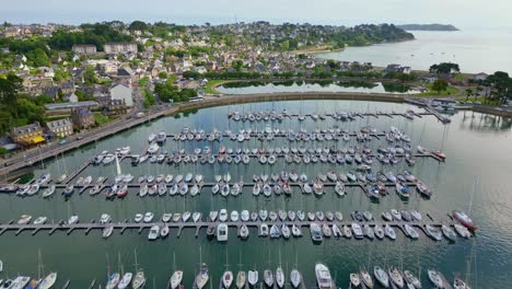 drone flying over perros-guirec harbor with sailboats, coastal town, bridge, brittany, france. aerial drone forward