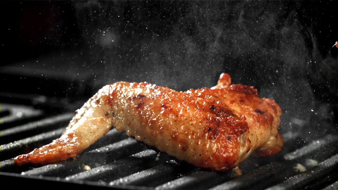 Gros plan d'une délicieuse aile de poulet grillant avec de la vapeur