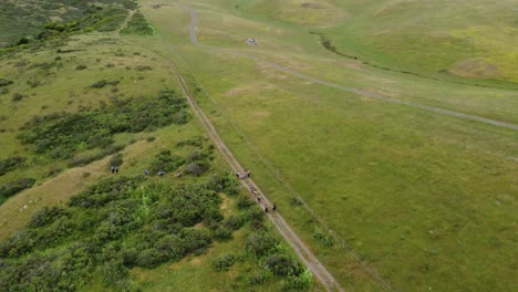 foto de adelantamiento de un grupo de amigos explorando amplias montañas verdes para acampar, california
