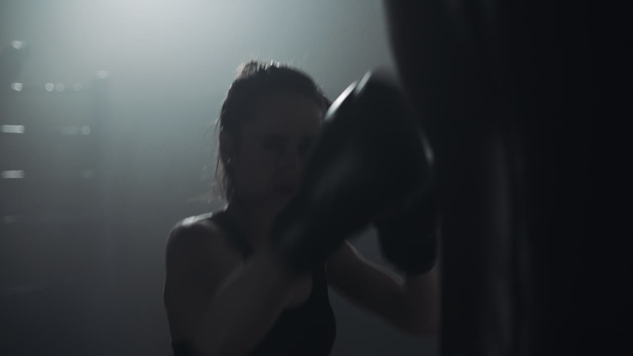 Donna che si allena a boxe con il sacco da boxe