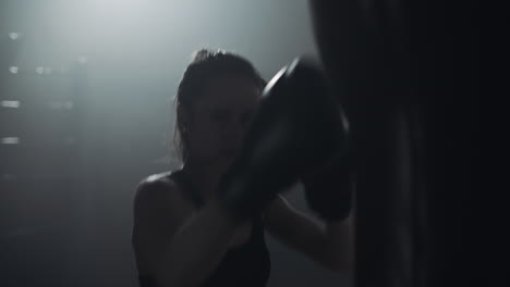 woman training boxing with punching bag