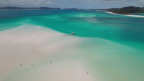 Descending-drone-shot-over-a-crowd-embarking-on-a-speed-boat-in-Whitehaven-beach-in-the-Whtsundays-islands-in-Queensland-Australia-on-a-nice-day