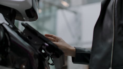 una programadora prueba el robot para la capacidad de interactuar con los usuarios. el uso de un asistente robot en la oficina. el robot da ayuda a la chica