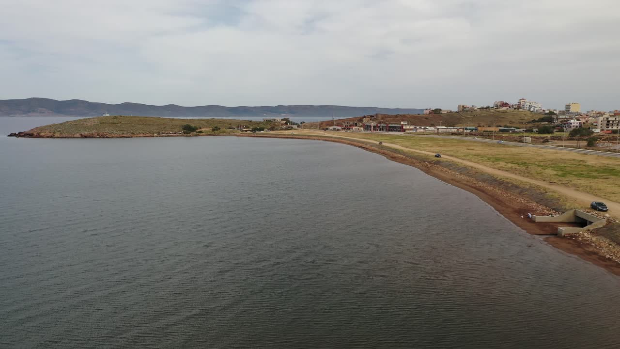 vuelo sobre e a lo largo de la costa del mar egeo, rodeado de tierra seca, arbustos áridos, sitios industriales, edificios abandonados