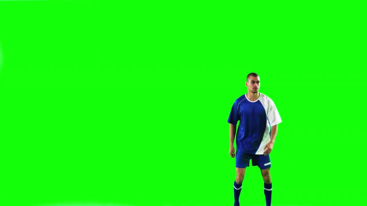 Athlete practicing soccer against green screen