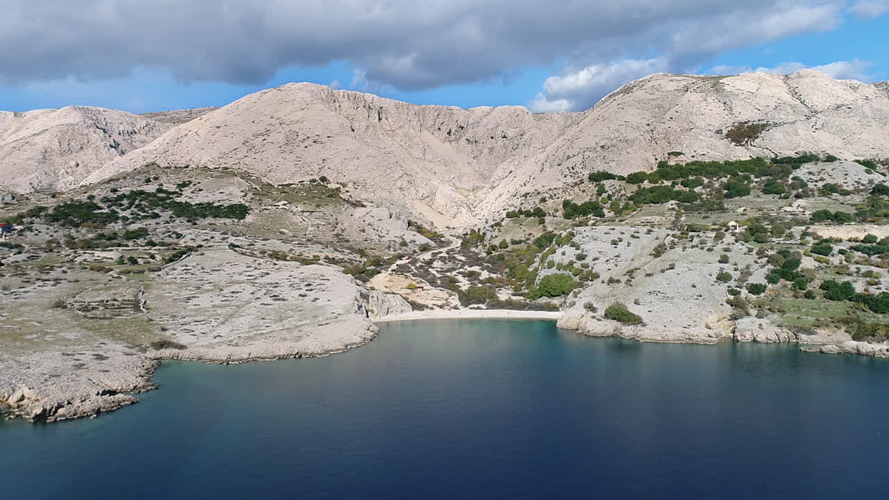 Aerial of a beautiful beach surrounded by mountains on the coast near Baska, Croatia