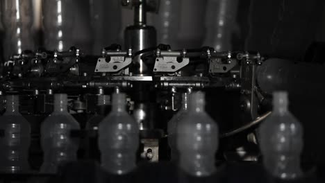 Close-Up-Shot-of-Plastic-Bottles-on-a-Rotating-Machine-at-a-Factory-Being-Prepared-to-be-Filled-with-Fresh-Vinegar