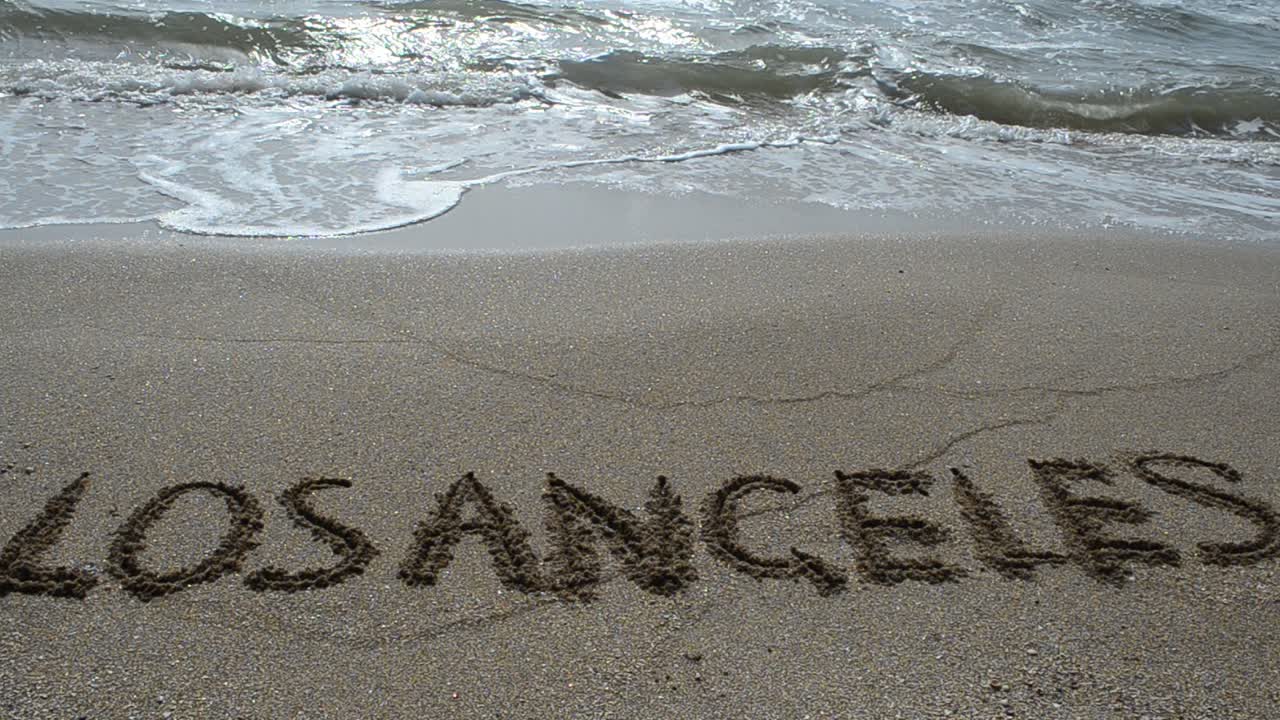 Indskrift i sandet. Optagelse på stranden.