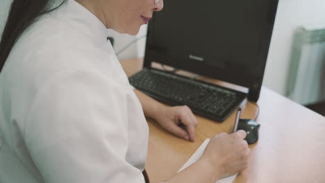 female doctor writes a prescription on a piece of paper