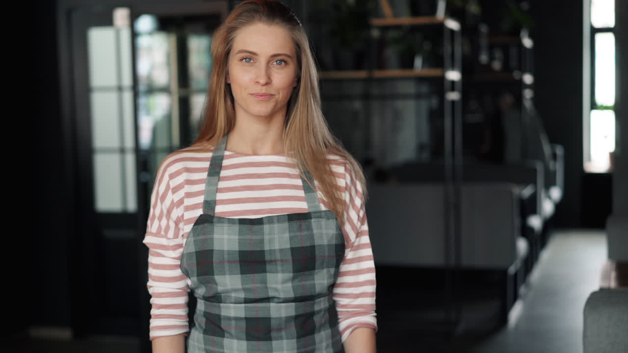 Женщина держит табличку «Открыто» в магазине
