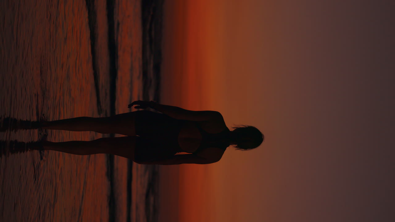 mujer en la playa durante la puesta del sol