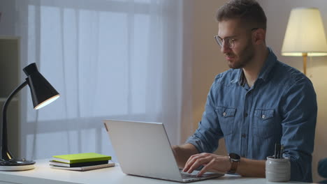 Männlicher-Programmierer-Arbeitet-Von-Zu-Hause-Aus-Und-Tippt-Auf-Dem-Laptop.-Fernarbeit-Und-Freiberuflicher-Teilzeitjob.-Porträt-Eines-Jungen-Mannes-Im-Zimmer