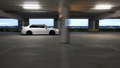 Drone-shot-of-a-car-driving-in-a-car-park