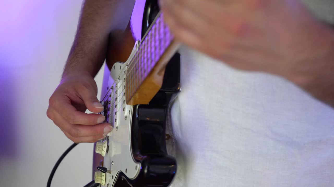 captura de detalle del guitarrista tocando un instrumento
