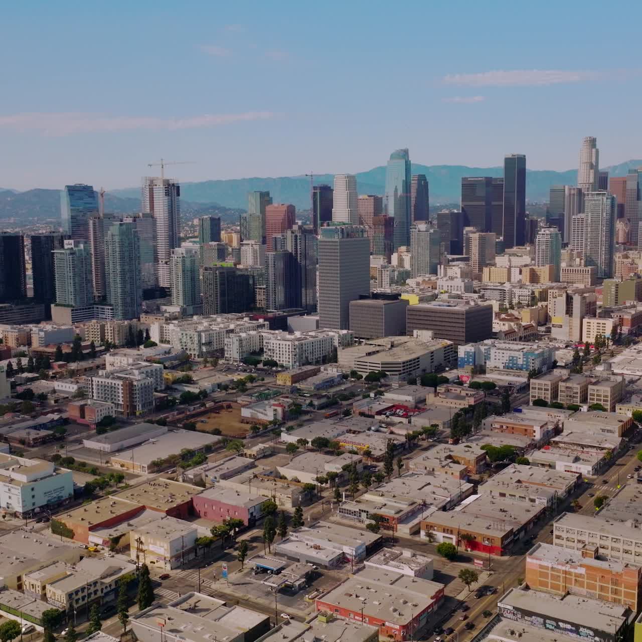 High buildings of amazing financial district in Los Angeles, USA. Hazy hills of California at backdrop. Aerial view