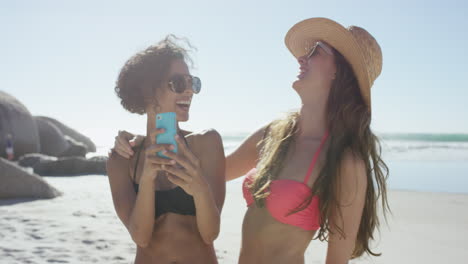 two friends taking selfies on the beach