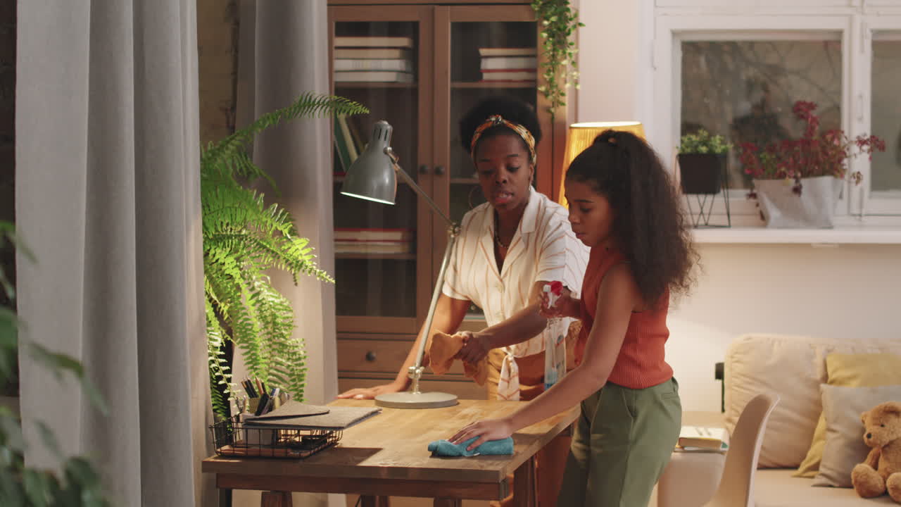 Afro Mom And Daughter Cleaning Table Together