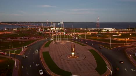 cars circle roundabout with argentina and south america country flags in center