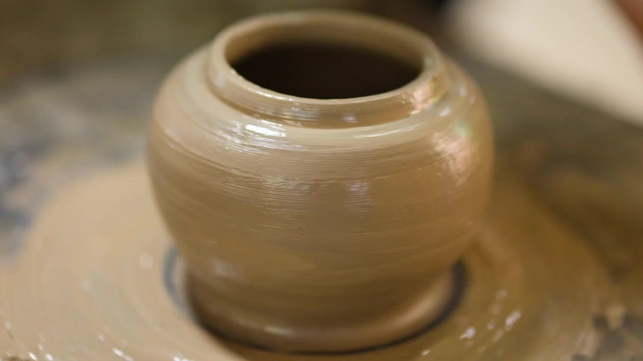 Un vaso di argilla bagnato ruota su un tornio in un laboratorio di ceramica in Thailandia