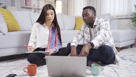 African man and his colleague caucasian young woman working together at home, teamwork.