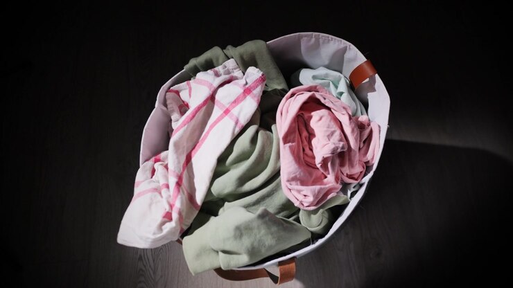 Topdown view of laundry basket being filled with dirty clothes