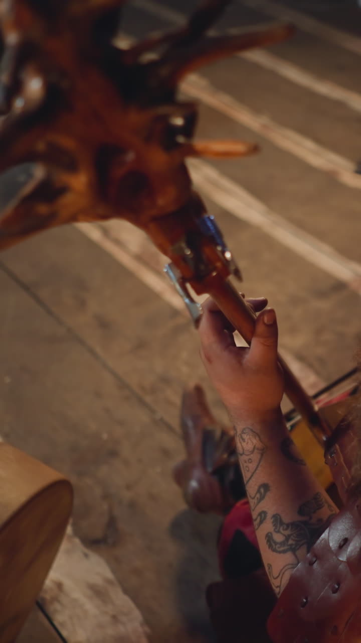 Yakut man with beard in national costume plays string instrument decorated with roots on stage backside view. Traditional music of Siberian folks