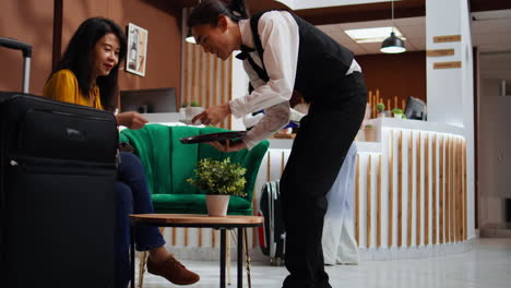 Hotel-guest-reading-and-signing-registration-forms-in-lobby