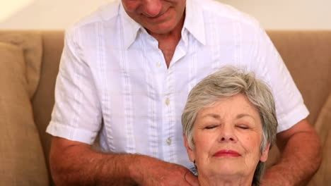 un anciano cariñoso dando a su esposa un masaje en el hombro