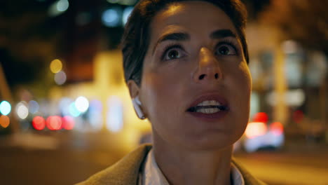 mujer hablando calle nocturna en auriculares primer plano gerente exitoso asentimiento consulta