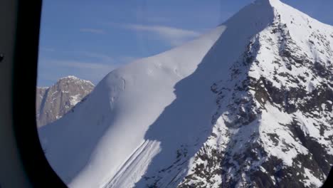 flying very close to mountains with snow covered peaks in alaska