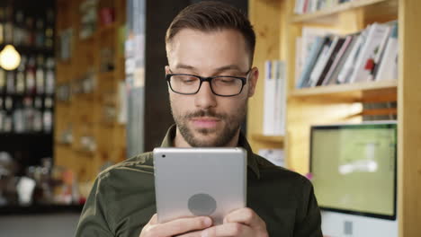 man using tablet in coffee shop