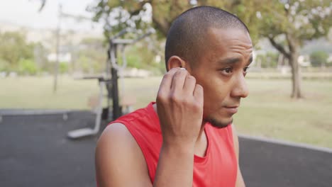 hombre de vista lateral con pierna protésica poniendo auriculares