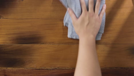 overhead shot of hand wiping the table with rag - close up