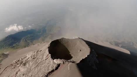 aerial view over crater of fuego volcano in guatemala on a sunny day