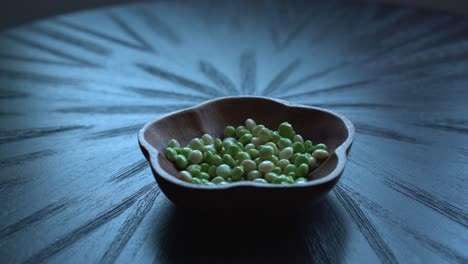 hands inside bowl of pigeon peas taken out of pod on table after being picked from tree healthy green fresh protein cultivation harvested