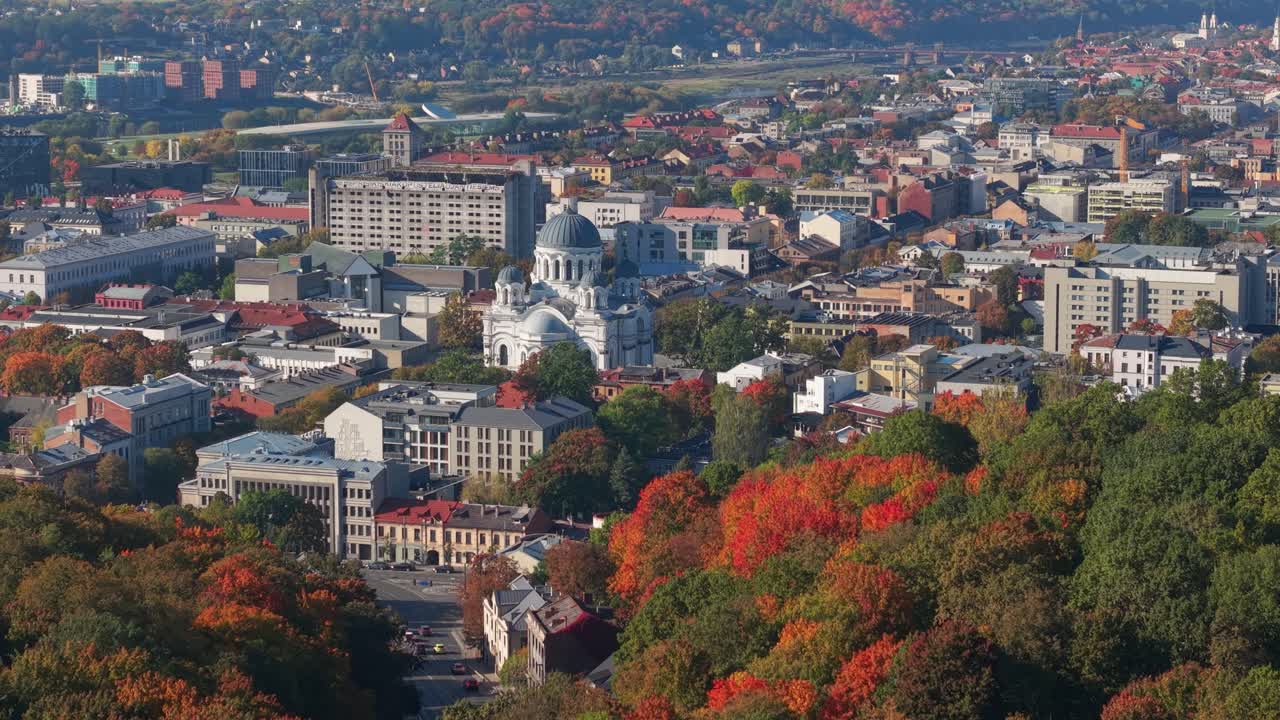 Scenic aerial view of Kaunas, Lithuania in autumn with the Church of St. Michael the Archangel surrounded by colorful trees and dense urban architecture