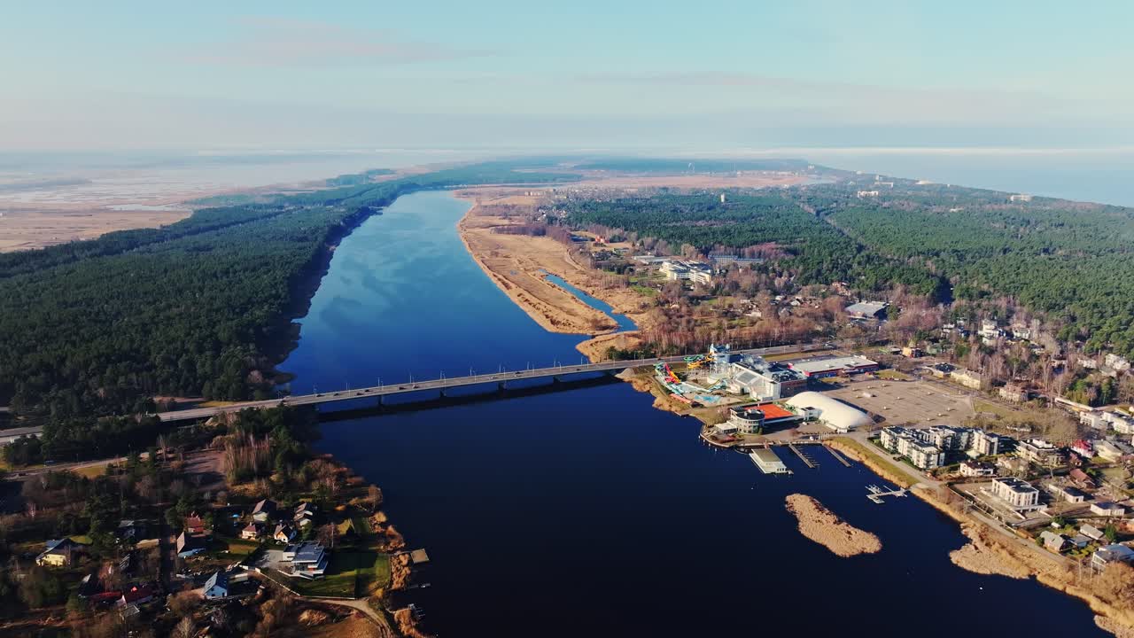 Ripresa aerea con drone del ponte sul fiume Lielupe, foreste e acqua, strada costiera per Jūrmala