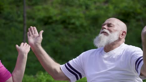 senior man meditating in park with his wife