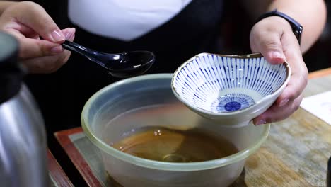 person pours sauce into a larger bowl