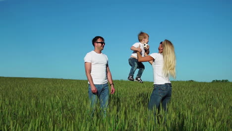 glückliche familie auf dem feld an einem sonnigen tag im park, die spaß hat und zeit miteinander verbringt. der sohn sitzt auf den schultern seines vaters