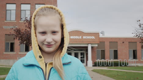 portret van een student op de achtergrond van een middelbare schoolgebouw in de verenigde staten